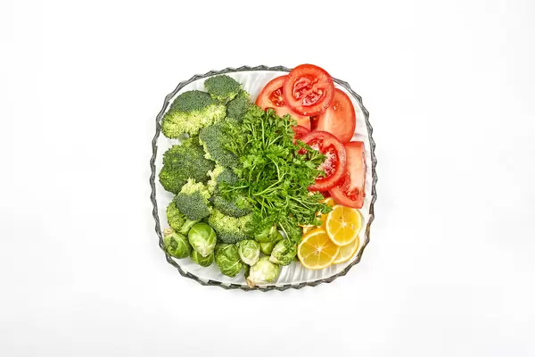 Brussels sprouts, broccoli, tomato and lemon slices on the plate