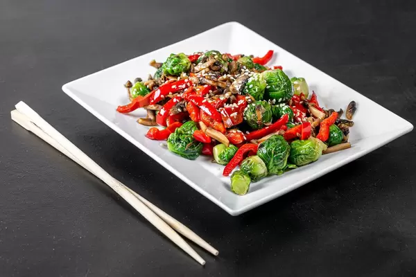 Brussels sprouts, sliced mushrooms and bell peppers with sesame seeds on a black background (Flip 2019)