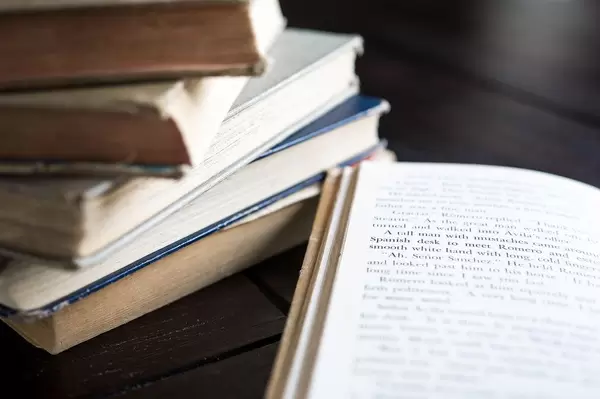 Bücherstapel und ein aufgeschlagenes Buch