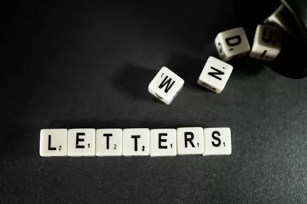 Buchstaben-Würfel ergeben das Wort "Letters", auf einer schwarzen Oberfläche