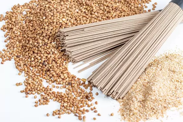 Buckwheat noodles with buckwheat groats and flour on a white background