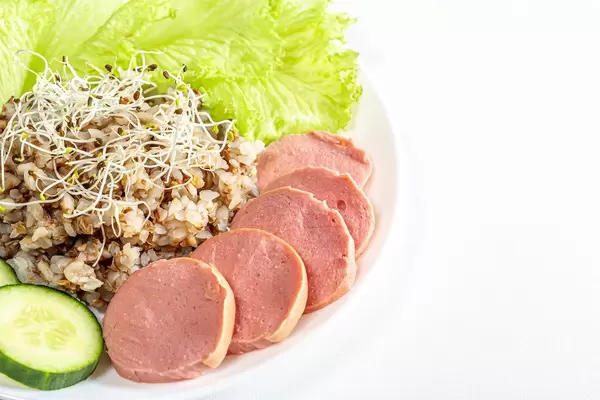 Buckwheat porridge with sausage, lettuce leaves, cucumber and alfalfa micro greenery