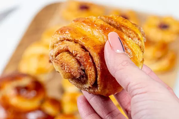 Bun roll with cinnamon in a woman's hand (Flip 2019)
