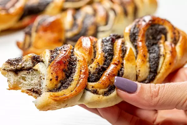 Bun with poppy seeds in a woman's hand (Flip 2019)