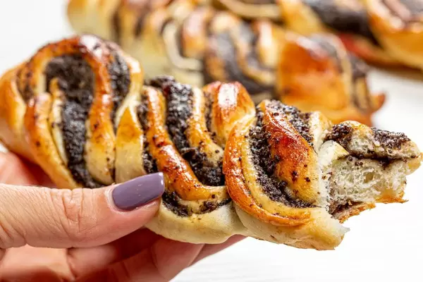Bun with poppy seeds in a woman's hand