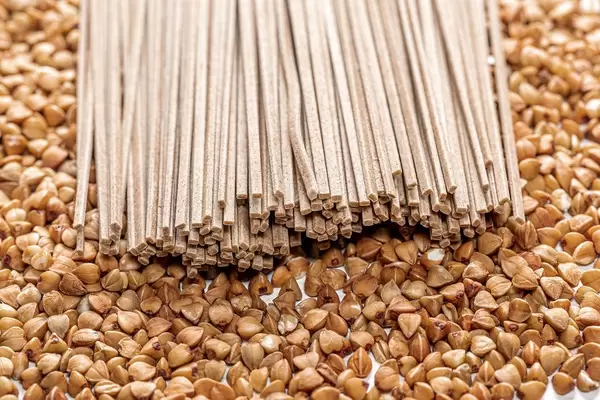 Bündel aus Buchweizen Soba Nudeln auf Buchweizen als Hintergrund