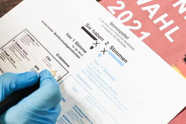 Bundestagswahl 2021: Hand eines Wählers mit Einmalhandschuh wählt für die CSU als Erststimme