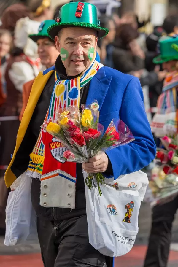 Bunt gekleideter Mann mit Rosen in seiner Hand - Kölner Karneval 2018