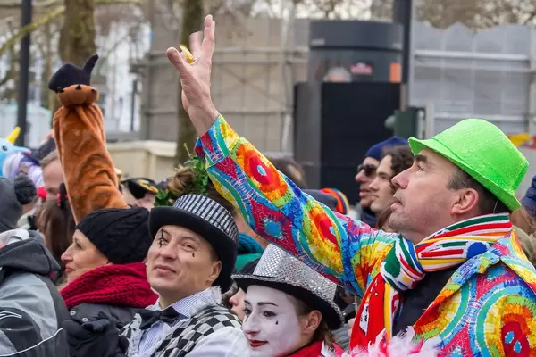 Bunt gekleideter Mann versucht eine Blume zu fangen - Kölner Karneval 2018