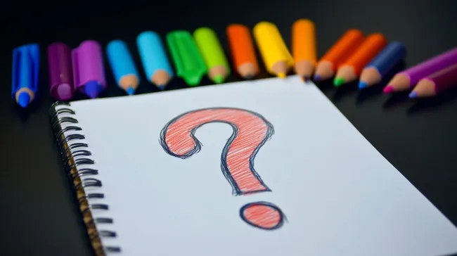 Bunte Buntstifte und Fragezeichen-Skizze