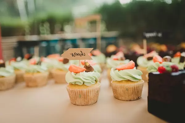 Bunte Cupcakes mit grünem Frosting und Erdbeeren