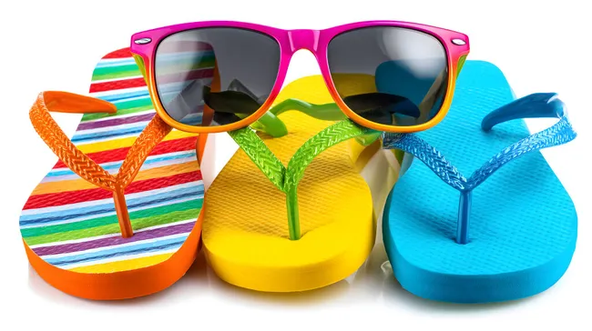 Bunte Flip-Flops und Sonnenbrille auf weißem Hintergrund