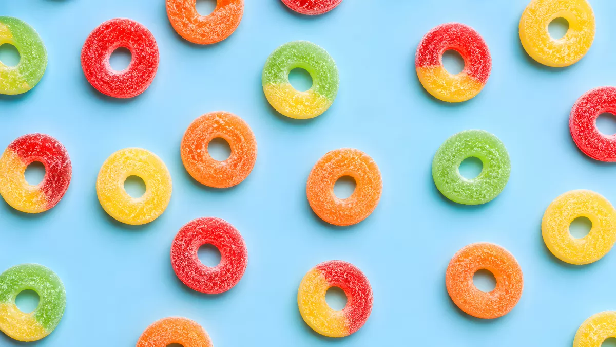 Bunte Fruchtgummi-Ringe auf hellblauem Hintergrund