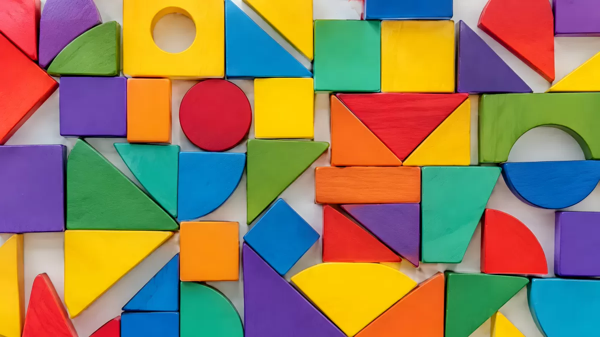 Bunte Holzbausteine in verschiedenen Formen arrangiert