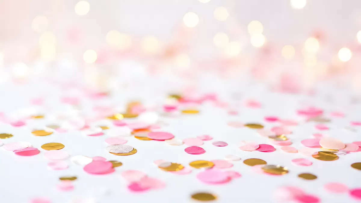 Bunte Konfetti-Kreise in Pink und Gold auf Weiß