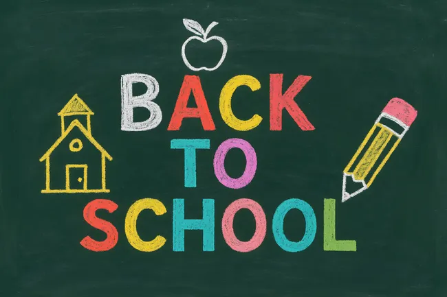 Bunte Kreide-Beschriftung 'Zurück zur Schule' auf Schiefertafel