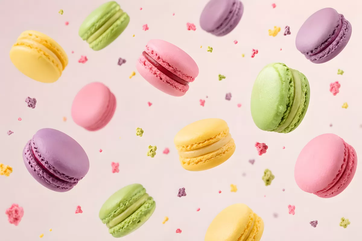 Bunte Macarons schweben vor hellem Hintergrund