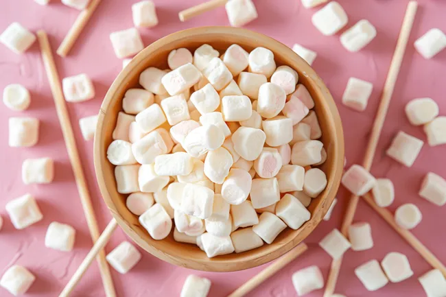 Bunte Marshmallow-Stückchen in Holzschale