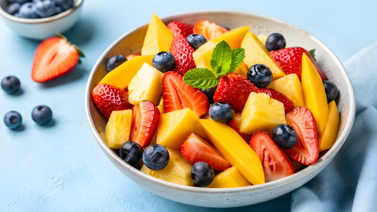 Bunte Obstschüssel mit Mango, Erdbeeren und Blaubeeren