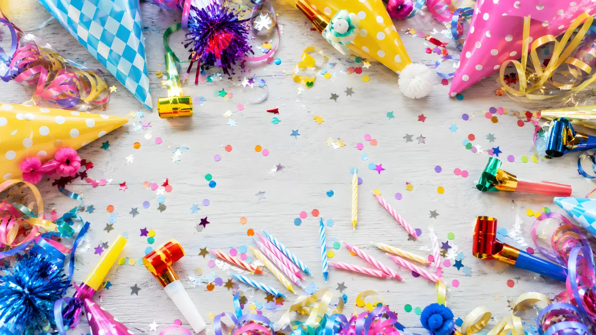 Bunte Partydeko mit Konfetti und Geburtstagshüten