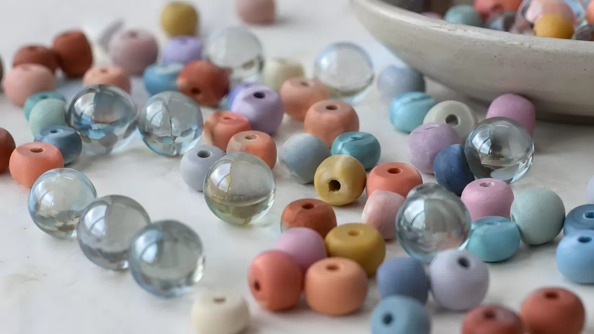 Bunte Perlen in Pastellfarben auf weißer Fläche
