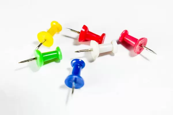 Bunte Pins vor weißem Hintergrund