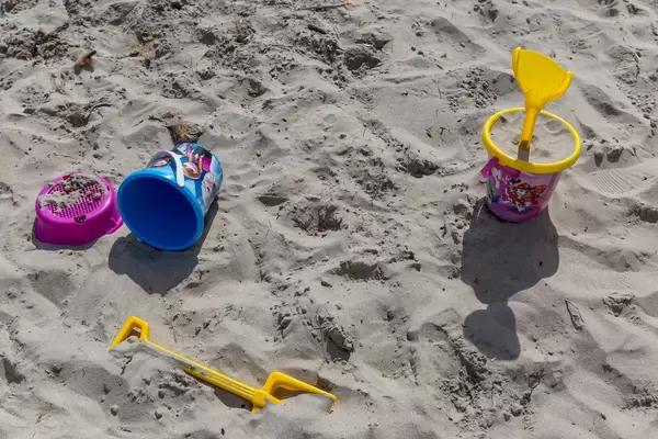 Bunte Sandeimer und Schaufeln am Strand