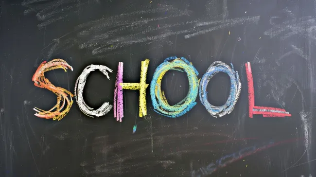 Bunte Schulkreide auf schwarzer Tafel