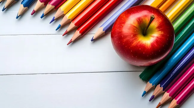 Bunte Schulutensilien mit rotem Apfel auf Holzuntergrund