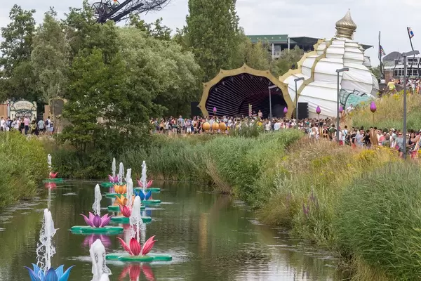 Bunte Seerosebrunnen am See von Tomorrowland Festival mit Party-Leuten im Hintergrund