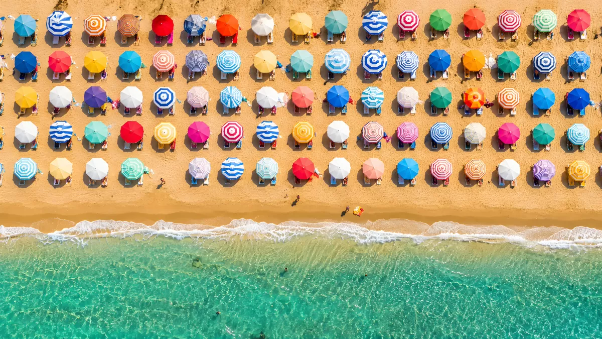 Bunte Sonnenschirme am Strand aus der Vogelperspektive