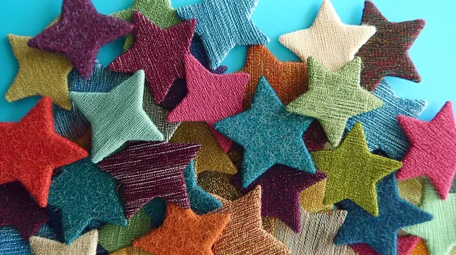 Bunte Stoffsterne in verschiedenen Farben auf Türkis