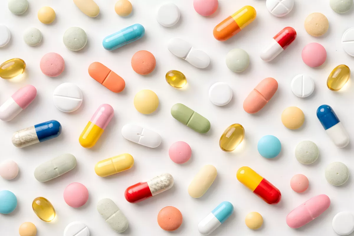 Bunte Tabletten und Kapseln auf weißem Hintergrund