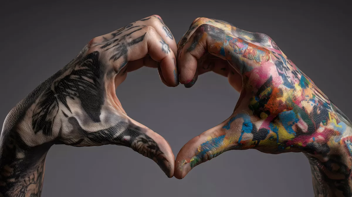 Bunte, tätowierte Hände formen Herz