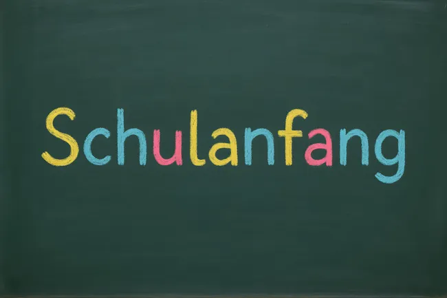 Bunter Kreidetext 'Schulanfang' auf Tafel
