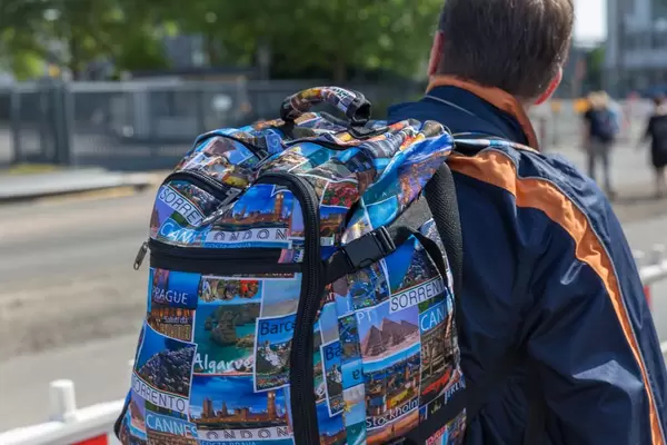 Bunter Reiserucksack mit Fotos von verschiedenen Reisezielen