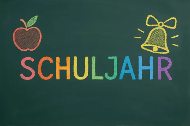 Bunter Schultafel-Hintergrund mit Apfel und Glocke