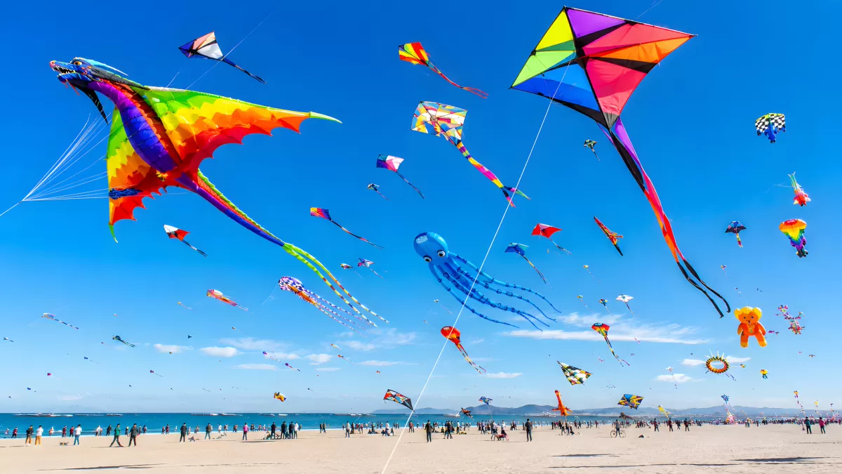 Buntes Drachenfest am Strand mit vielen Flugdrachen