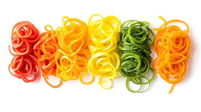 Buntes Gemüsespiralen-Arrangement in leuchtenden Farben