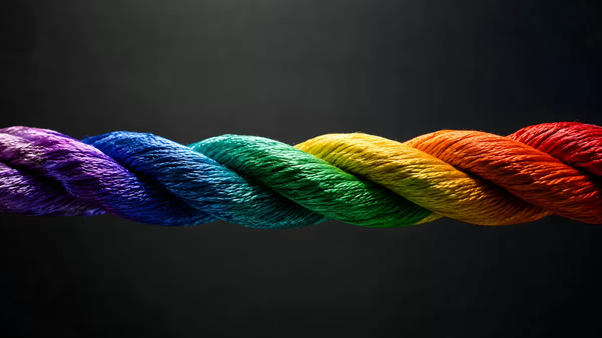 Buntes Seil in Regenbogenfarben vor dunklem Hintergrund