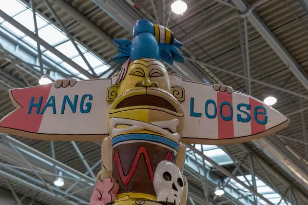 Buntes Totem mit Wegweiser mit Surfmotto Hang Loose