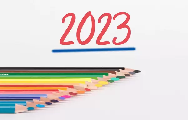 Buntstifte vor weißem Hintergrund mit rotem "2023" Text
