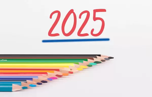 Buntstifte vor weißem Hintergrund mit rotem "2025" Text