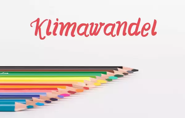 Buntstifte vor weißem Hintergrund mit rotem "Klimawandel" Text