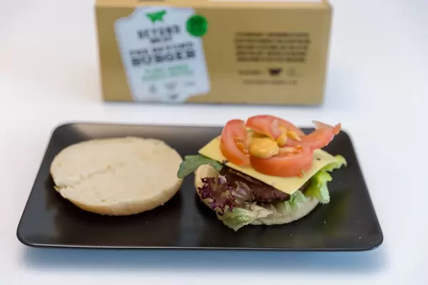 Burger bun with mixed salad, cheese, tomatoes and dip for a veggie burger of the Beyond Meat vegan and plant-based burger patties set