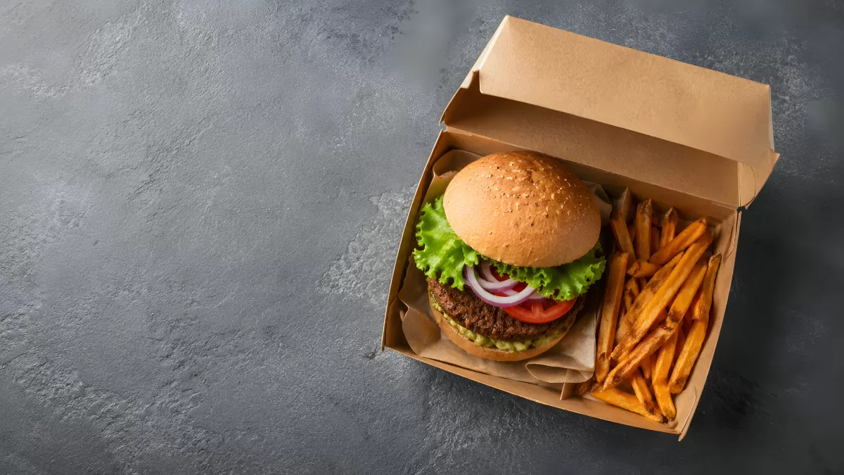 Burger mit Pommes in einer Kraftpapier-Box