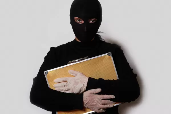 Burglar holding a bag full of money and gems