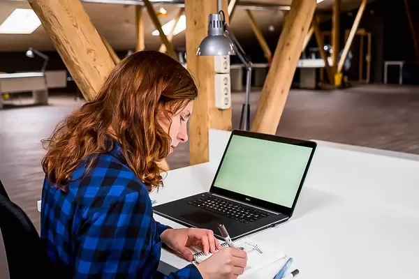 Büroarbeiten im großräumigen Dachgeschoss, mit Blatt Papier und Laptop