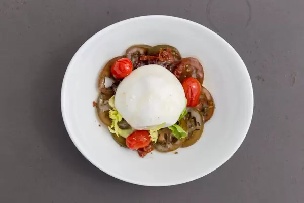 Burrata salad with tomato compote on a white dish at Hotel 1898 in Barcelona