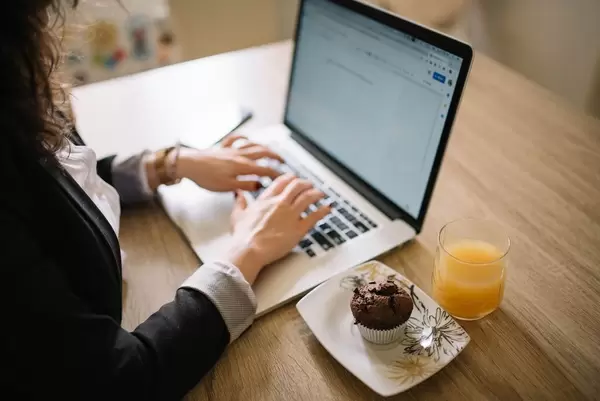 Business woman starting off her work day with a muffin and orange juice